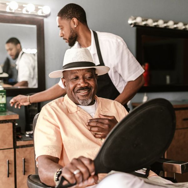 man smiling a himself at barbershop