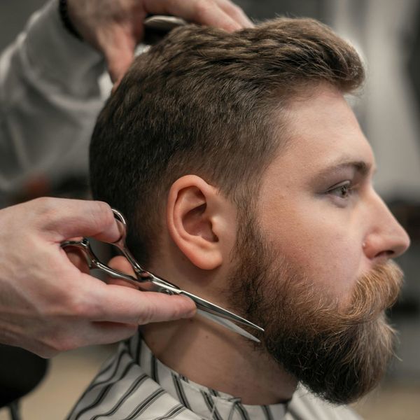 man getting beard trimmed at barbershop